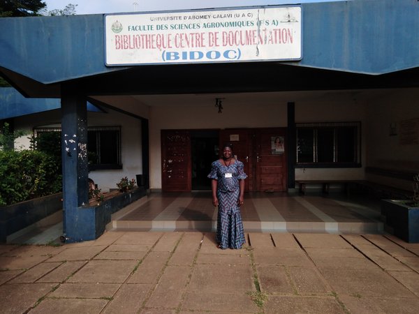 Young female student standing in front of university building