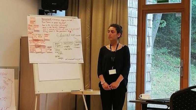 Margarit Tigranyan, a university lecturer from Armenia,  in front of a flipchart during the Organic Leadership Course in Lithuania