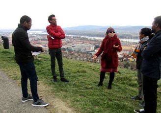 Five people standing on a path, overlooking a city