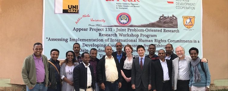 group foto of workshop participants with participants standing in front banner