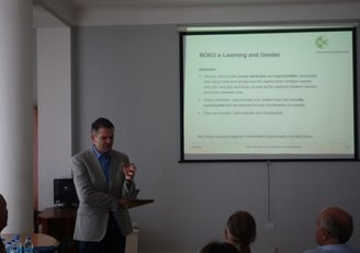 Man standing in front of a presentation talking about something in front of a group