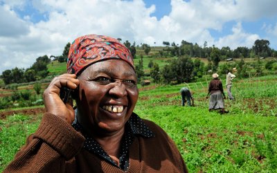 A Kenyan farmer uses a mobile phone in the field