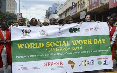 Demonstrationszug hält Banner hoch am Tag der Int. Sozialen Arbeit in Kigali/Ruanda