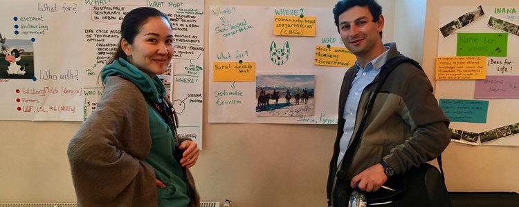 Two scholars in front of flip chart presenting their work