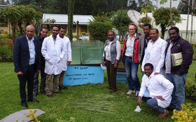 Scientists standing in the premises of the research center and posing next to aquarium 