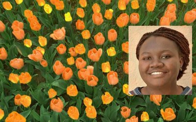 Portrait of Anne Birundi with yellow and orange tulips in the background
