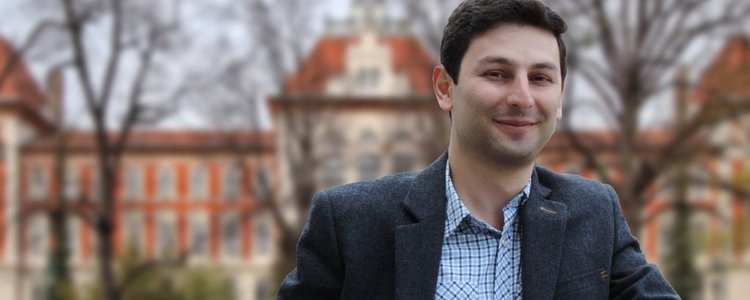 Portrait of Alumnus Tigran Keryan in front of an university building 