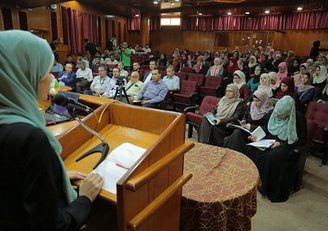 Female speaker at symposium in front of audience