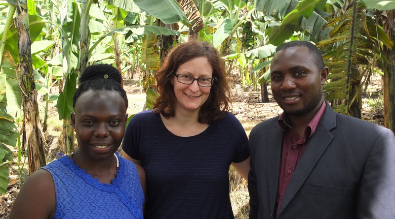 Two APPEAR scholars and one APPEAR representative posing for a photo in front of banana plants