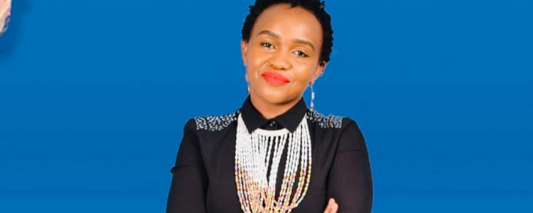 Sonnia Musyoka sitting on a chair in front of a blue background