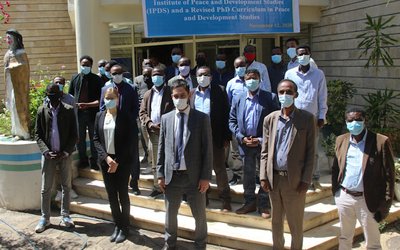 A group of researchers wearing face masks standing in front of a university building