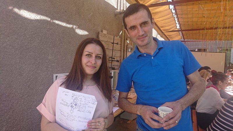 Scholarship holder Hasmik Hovakimyan holding her workshop notes and standing next to a workshop participant